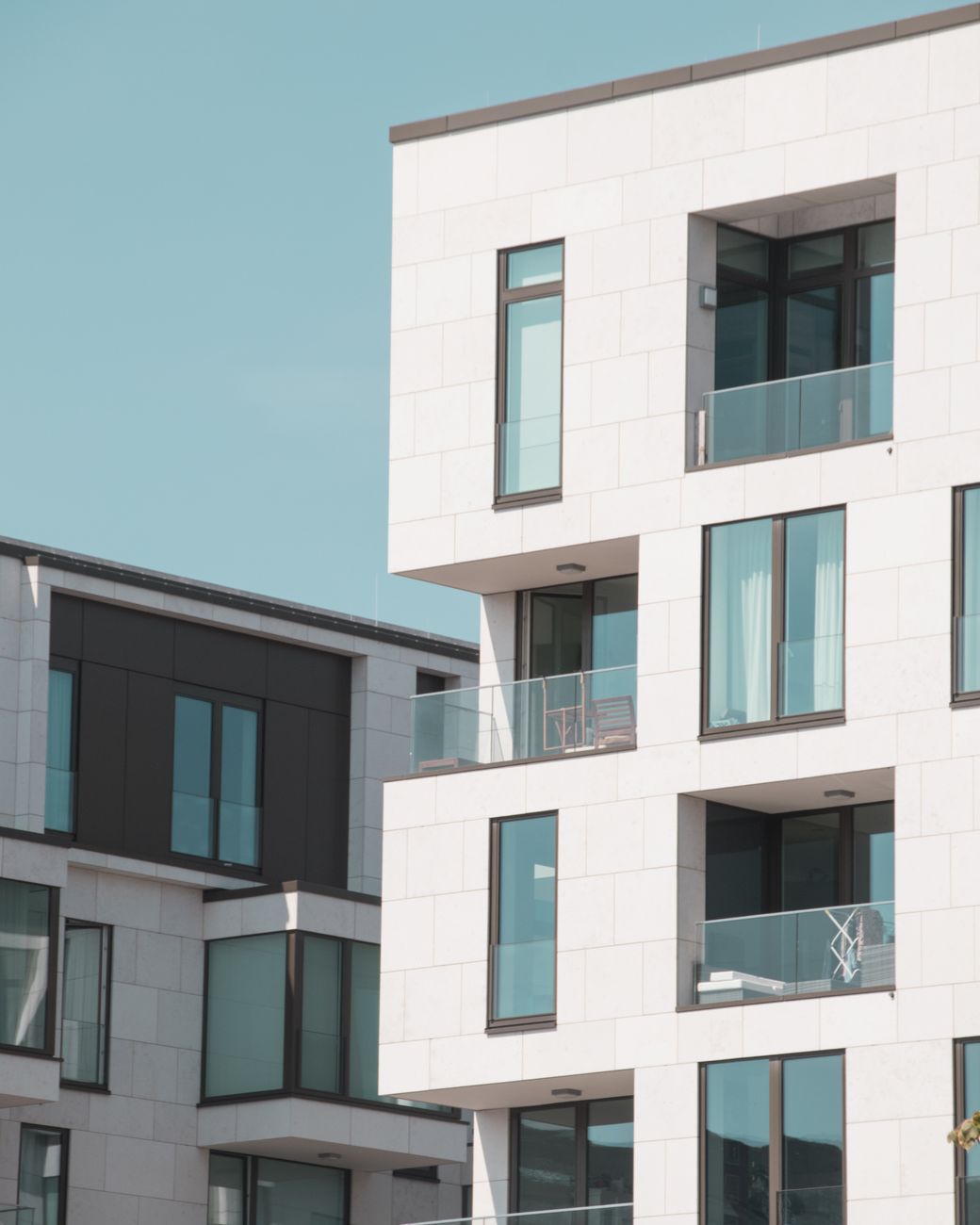 Contemporary residential building with white facade and glass balconies