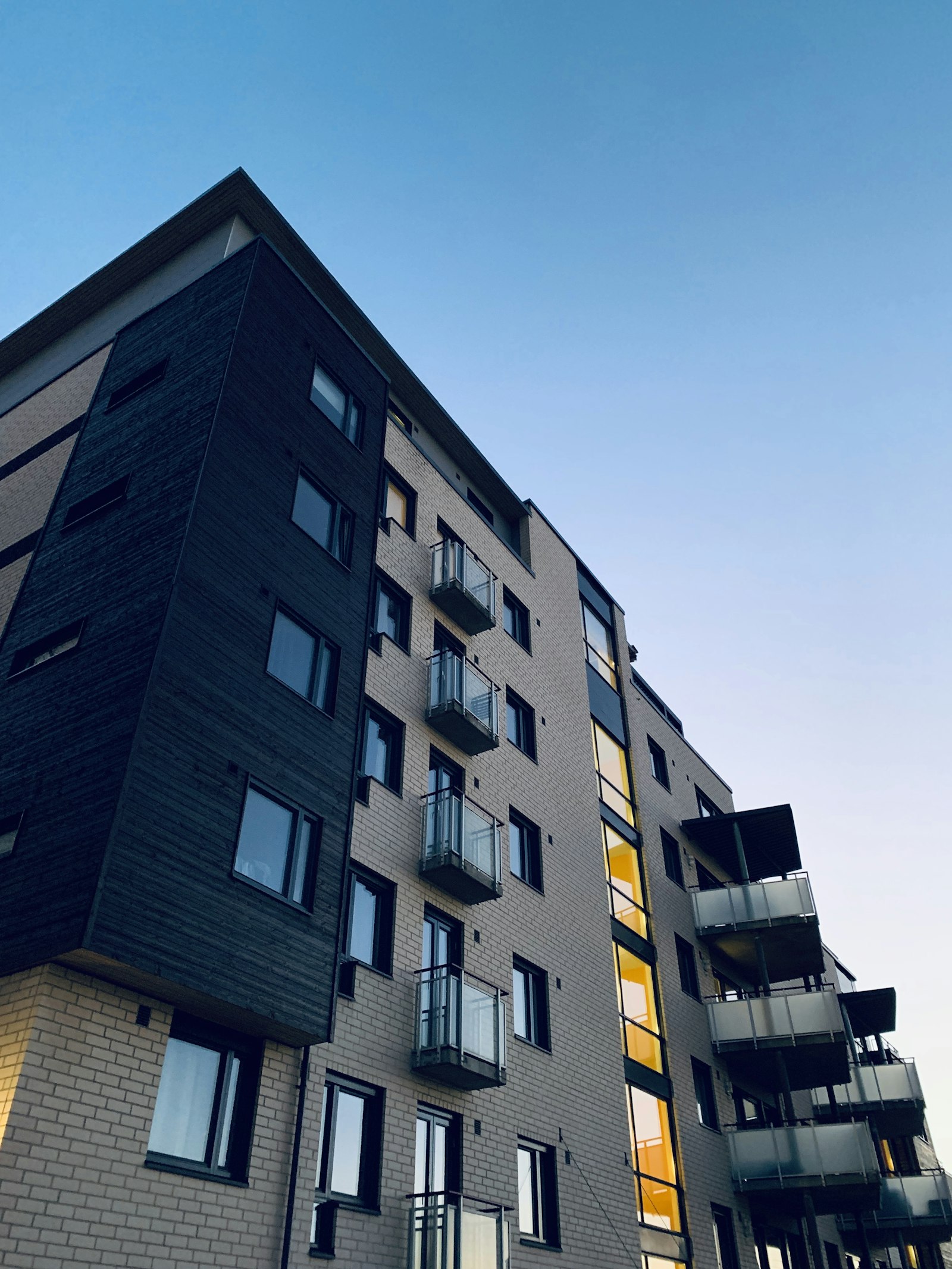 Modern residential building facade at dusk with lit balconies, symbolising new real estate opportunities